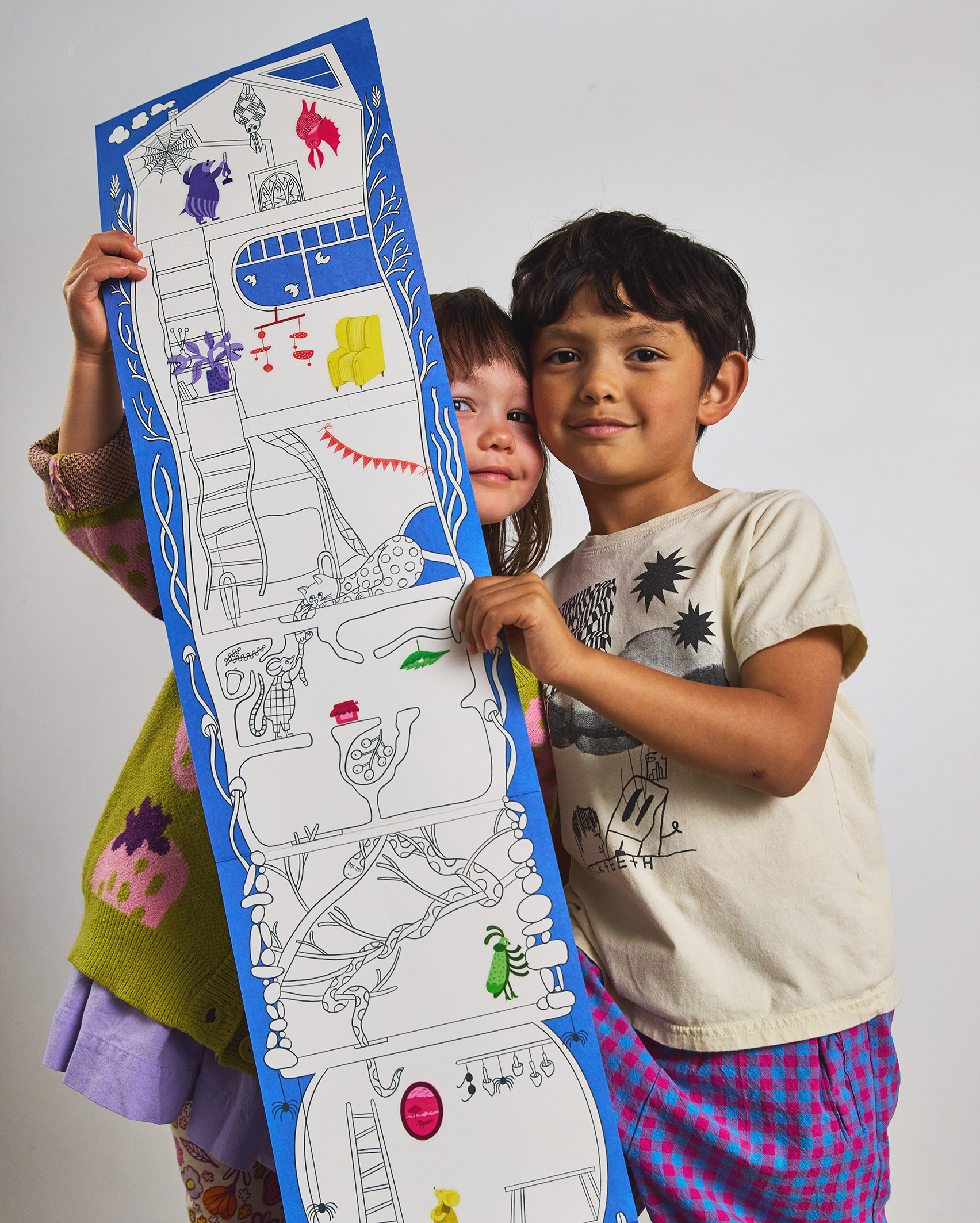 A child holding up a tall illustrated activity sheet.