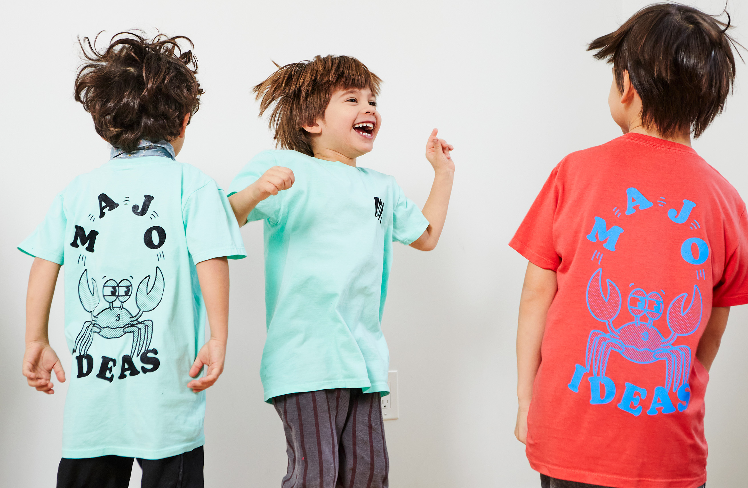 Three kids wearing Majo Ideas t-shirts.